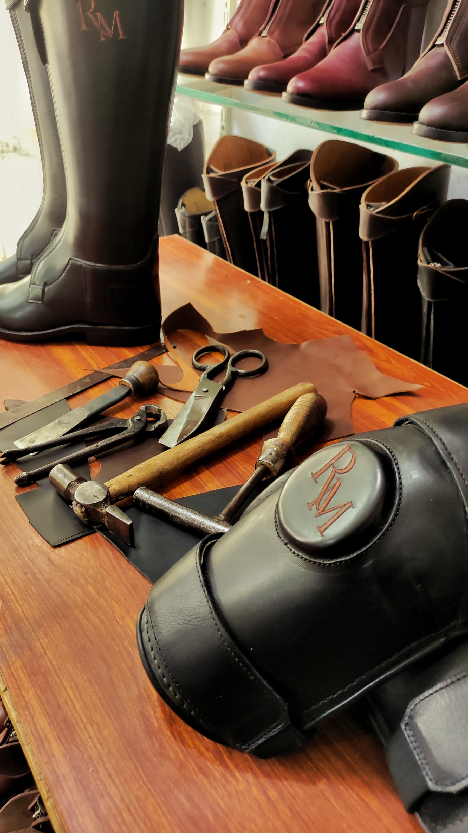 Hand stitched knee guard on the workbench with leatherworking tools
